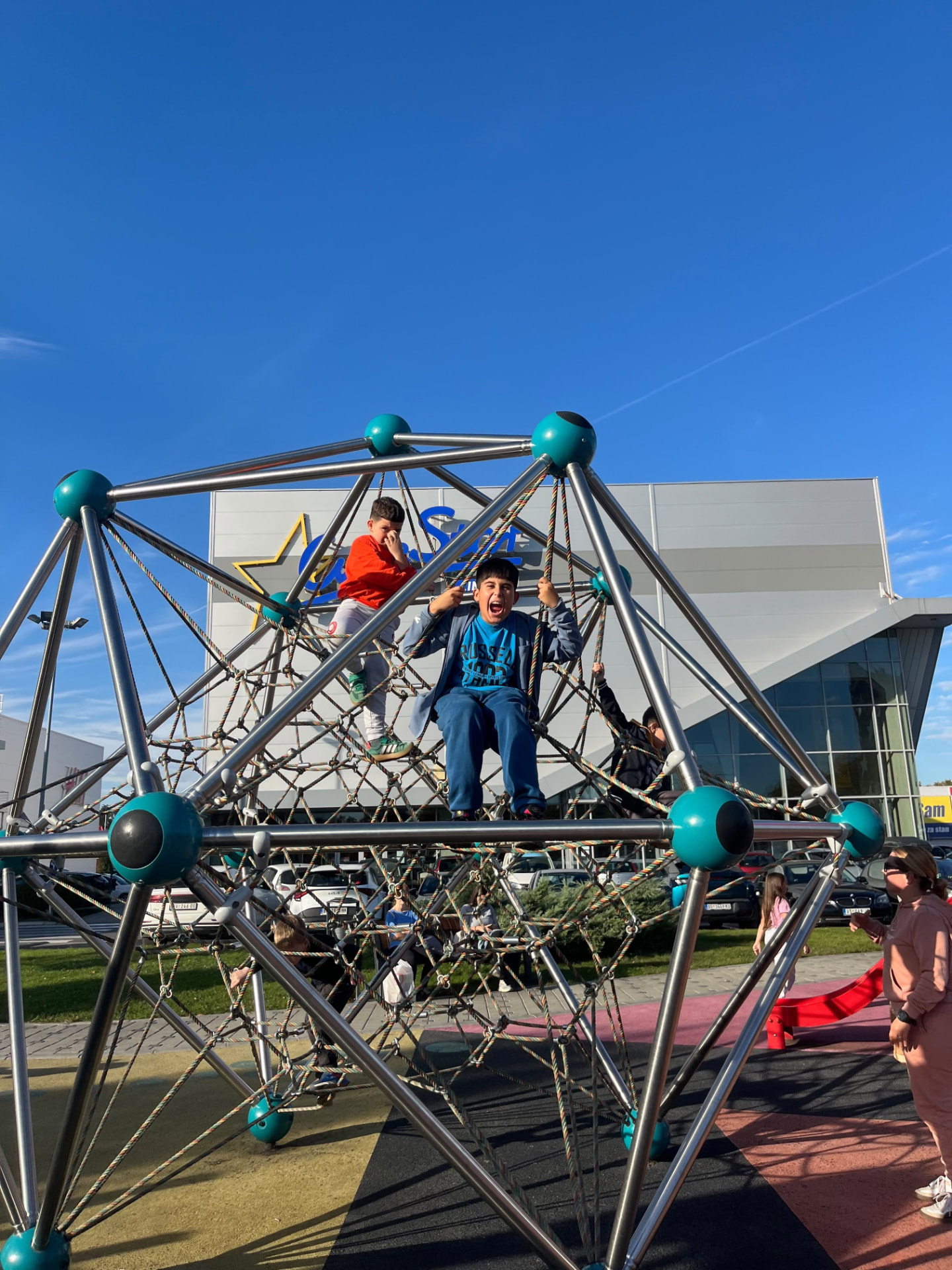 Club kids climbing a rope pyramid on a sunny day out