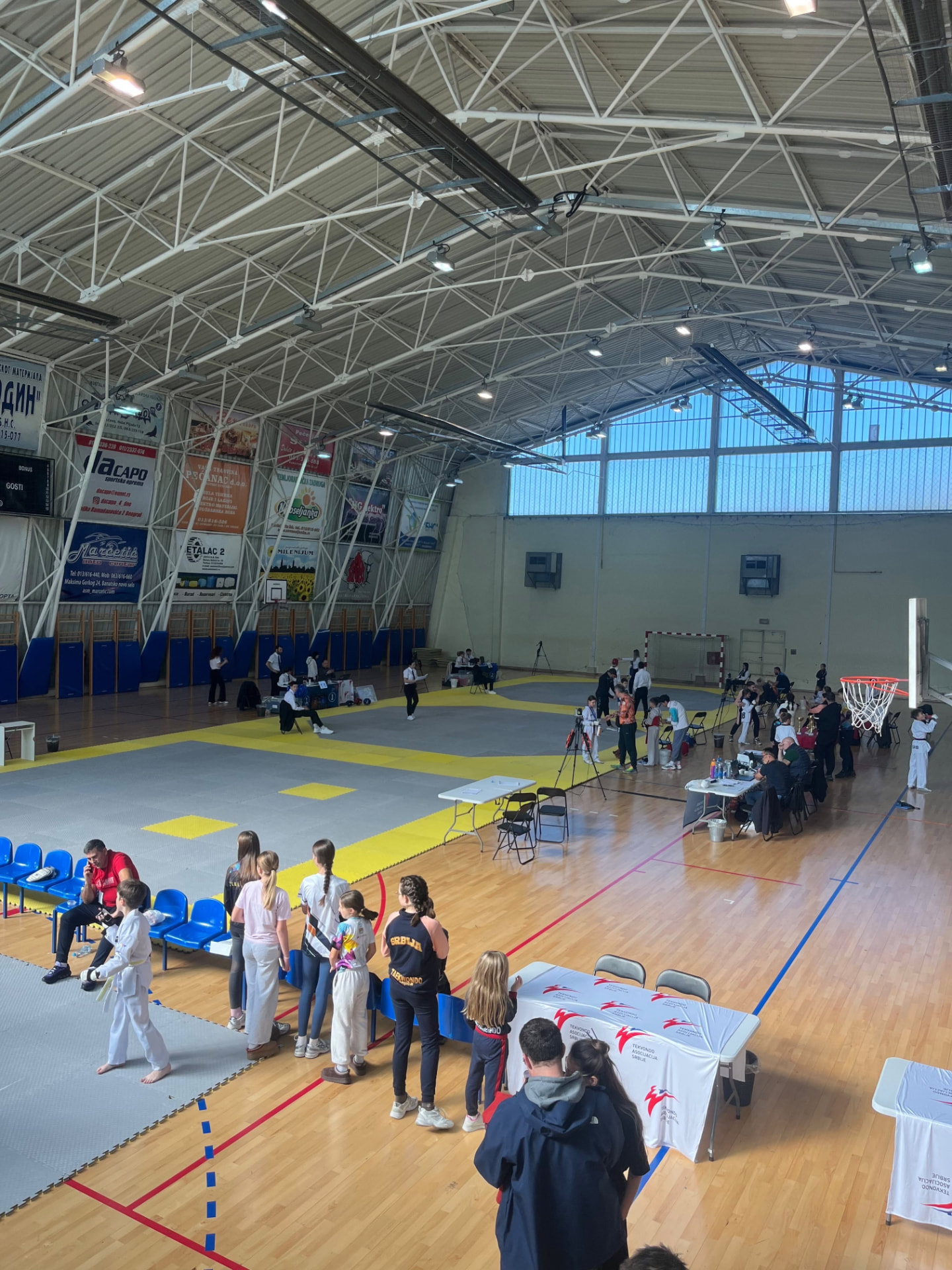 Wide view of a sports hall set up with taekwondo competition mats